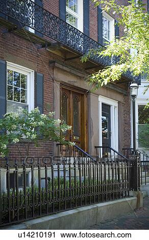 Stock Image - Brick apartment building with wrought iron fence. Fotosearch