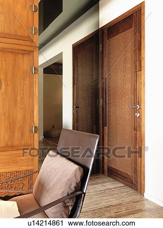 Stock Image - Chair and wooden door. Fotosearch