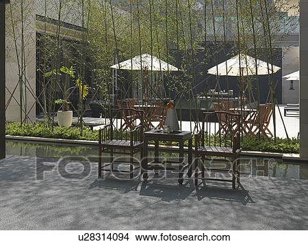 Picture - Chairs and end table on patio. Fotosearch