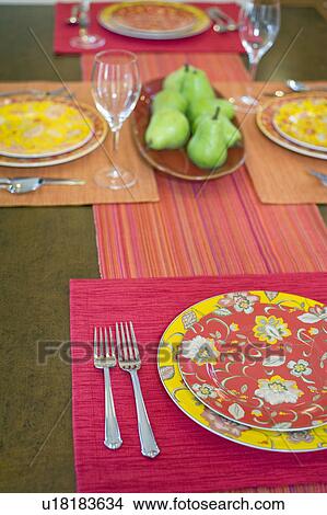 Picture - Colorful place settings on dining room table. Fotosearch
