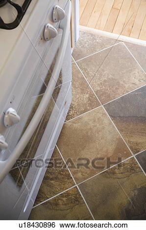 Stock Photograph - Detail oven and dark tile floor. Fotosearch
