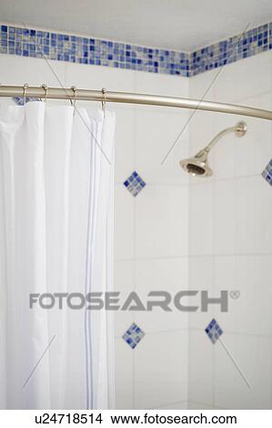 Picture - Detail shower curtain and shower head in blue and white tiled shower. Fotosearch