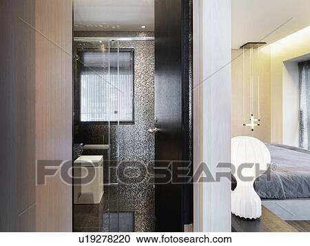 Stock Image - Doorway separating modern bathroom from bedroom. Fotosearch