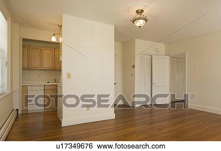 Stock Photograph - Empty apartment with hardwood floor and small kitchen. Fotosearch