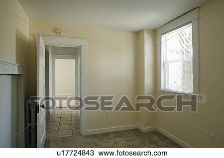 Stock Image - Empty room in apartment with carpeting and doorway to hallway. Fotosearch