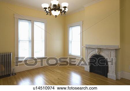 Picture - Empty room in apartment with hardwood floor and heater. Fotosearch