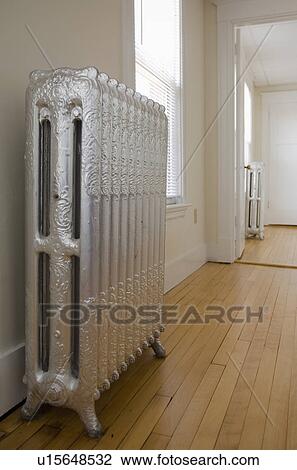 Stock Image - Empty room in apartment with hardwood floor and heater. Fotosearch