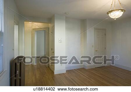 Stock Image - Empty room in apartment with hardwood floor and heater. Fotosearch