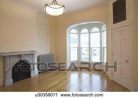 Stock Image - Empty room in apartment with hardwood floor and bay window. Fotosearch