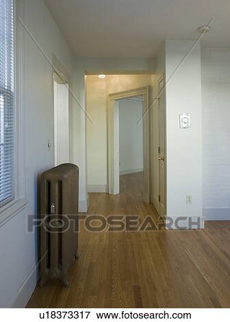 Empty room in apartment with hardwood floor and heater View Large Photo Image Stock Photo - Empty room in apartment with hardwood floor and heater. Fotosearch