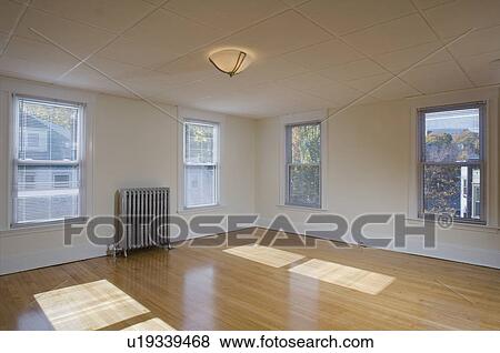 Stock Photo - Empty room in apartment with hardwood floor and heater. Fotosearch
