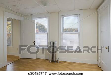 Empty room in apartment with hardwood floor and heater View Large Photo Image Stock Photo - Empty room in apartment with hardwood floor and heater. Fotosearch