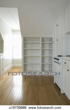 Stock Photograph - Empty room in apartment with hardwood floor and bookcase. Fotosearch