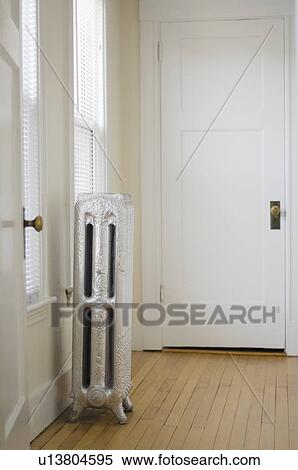 Stock Photography - Empty room in apartment with hardwood floor and heater. Fotosearch