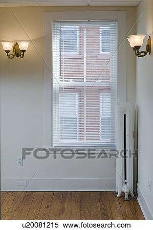 Stock Photography - Empty room in apartment with hardwood floor and heater. Fotosearch