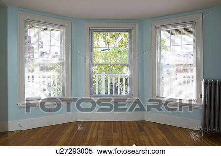 Stock Photography - Empty room in apartment with hardwood floor and heater. Fotosearch