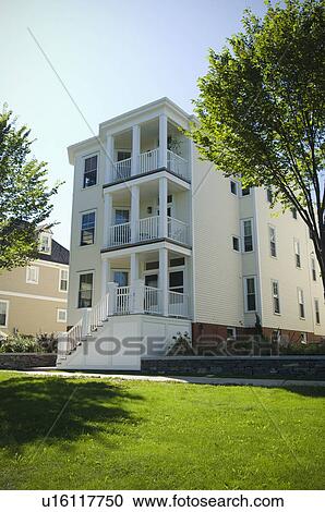 Stock Image - Exterior of multi level apartment home with porches. Fotosearch