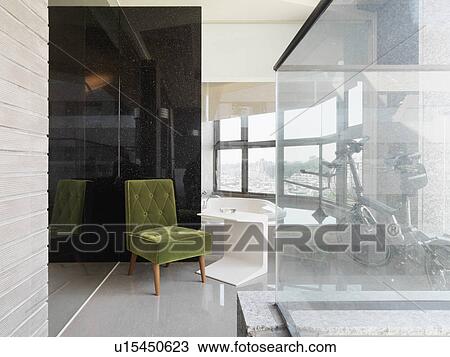 Stock Image - Green velvet chair in corner. Fotosearch