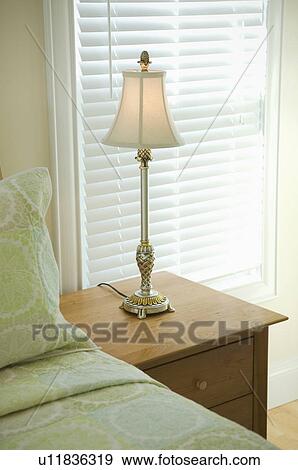 Lamp On Nightstand Beside Light Green Bed Stock Photo U11836319 Fotosearch