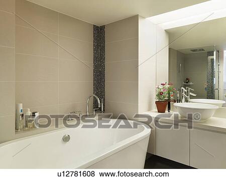 Stock Photo - Light colored modern bathroom with large bathtub. Fotosearch