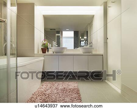 Stock Photo - Light colored modern bathroom with large bathtub. Fotosearch