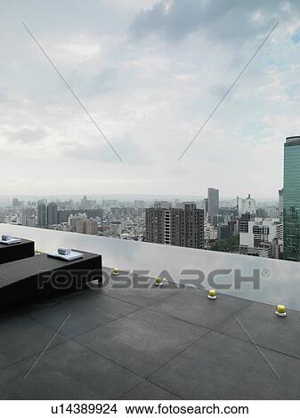 Lounge chairs on patio overlooking city View Large Photo Image Picture - Lounge chairs on patio overlooking city. Fotosearch