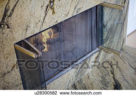 Stock Image - Marble fireplace with glass doors. Fotosearch