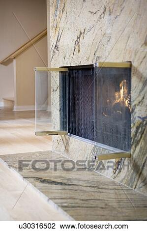 Stock Image - Marble fireplace with glass doors. Fotosearch