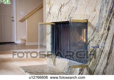 Stock Photograph - Marble fireplace with glass doors. Fotosearch