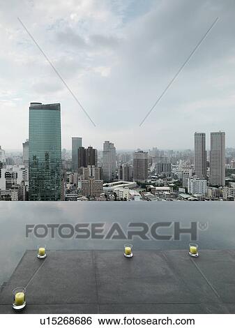 Stock Photograph - Patio and reflection pool overlooking city. Fotosearch