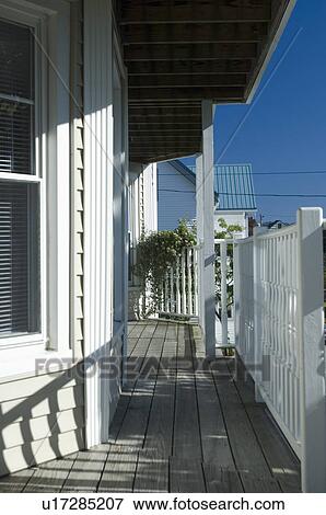 Stock Photo - Railing shadows on wooden front porch. Fotosearch