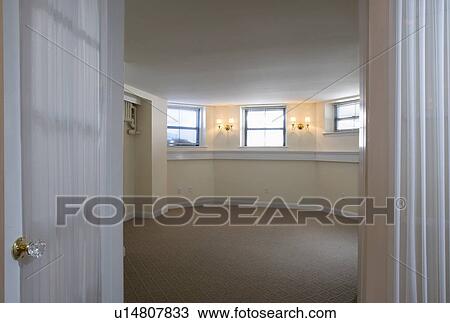Stock Image - Room in empty apartment with carpeting. Fotosearch