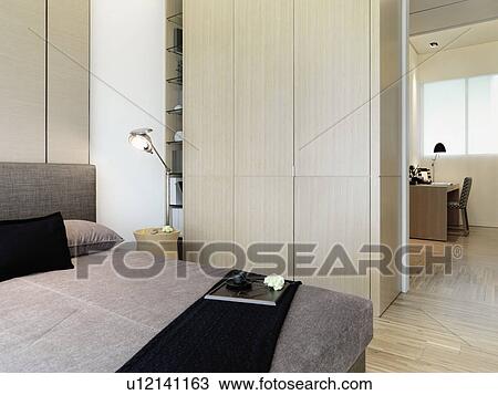 Stock Image - Serving tray on foot of modern bed. Fotosearch