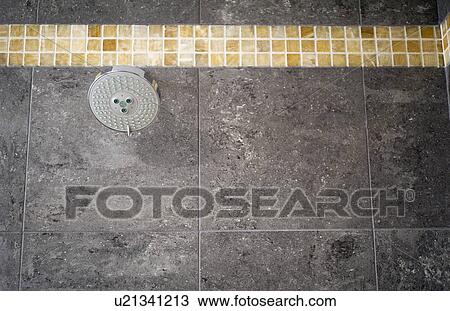 Stock Image - Showerhead in gray tile shower. Fotosearch