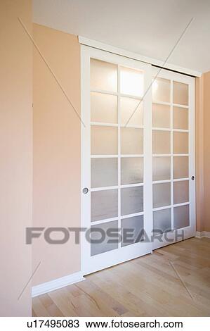 Stock Image - Sliding closet doors in peach colored room. Fotosearch