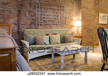 Stock Photo - Sofa and coffee table in small studio apartment. Fotosearch