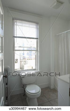 Toilet beneath window in small bathroom View Large Photo Image Stock Photo - Toilet beneath window in small bathroom. Fotosearch