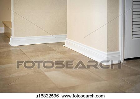 Stock Photograph - White baseboard along ceramic tile floor. Fotosearch