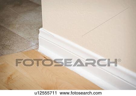 White baseboard along hardwood floor View Large Photo Image Stock Image - White baseboard along hardwood floor. Fotosearch