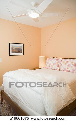 White Bed In Peach Colored Bedroom Stock Photography
