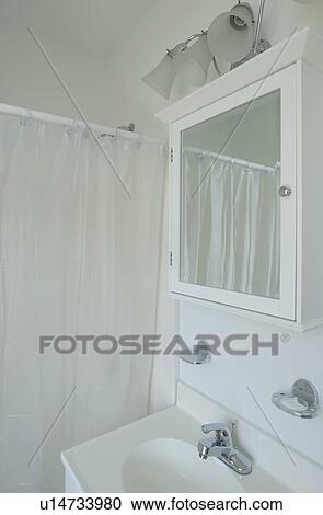 Stock Image - White sink medicine cabinet and shower curtain. Fotosearch