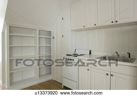 Stock Image - White stove and kitchen in empty apartment. Fotosearch