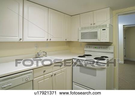 Stock Image - White stove and kitchen in empty apartment. Fotosearch