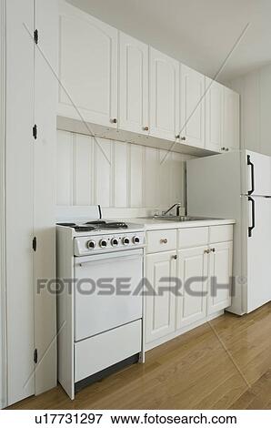 White stove and kitchen in empty apartment View Large Photo Image Stock Photo - White stove and kitchen in empty apartment. Fotosearch