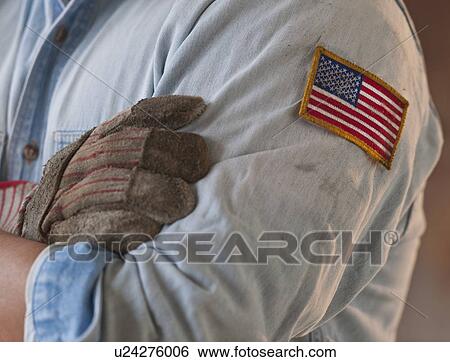 Stock Photograph - Blue collar working wearing American flag patch. Fotosearch