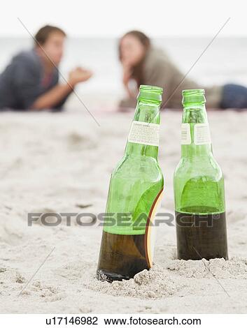 Stock Image - Bottles in sand. Fotosearch