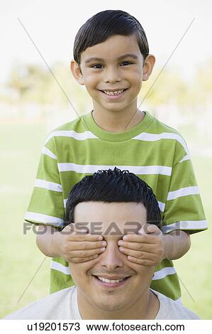 Boy covering man's eyes View Large Photo Image Stock Image - Boy covering man's eyes. Fotosearch