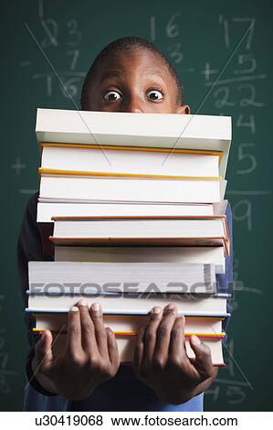 Stock Photo - Boy holding stack of books. Fotosearch