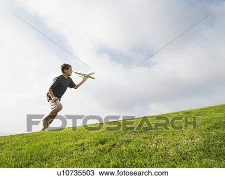 Boy playing with toy airplane View Large Photo Image Stock Image - Boy playing with toy airplane. Fotosearch