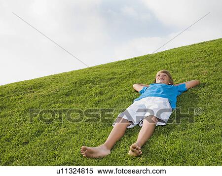 Stock Photography - Boy resting on grass. Fotosearch
